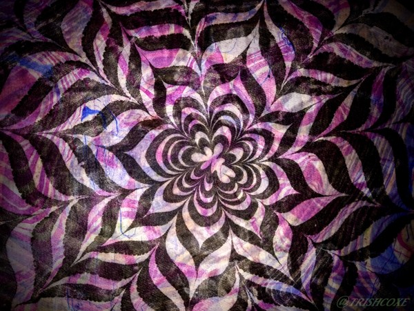 A black and white striped marbled flower design over handmade paper with purple details.